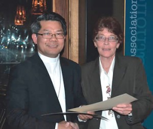 Joanne Oliver receiving one of the ACPA awards on behalf of Fr O’Connell from Bishop Vincent Long of Melbourne